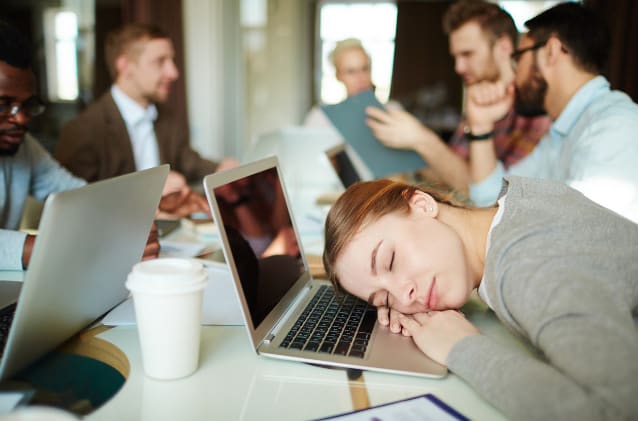 Photo of Person Asleep at Work for the Article A Guide to Better Sleep