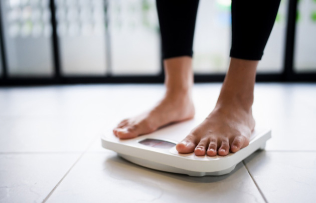 Photo of a person on a weighing scale for the blog post on the Best Peptides for Weight Loss